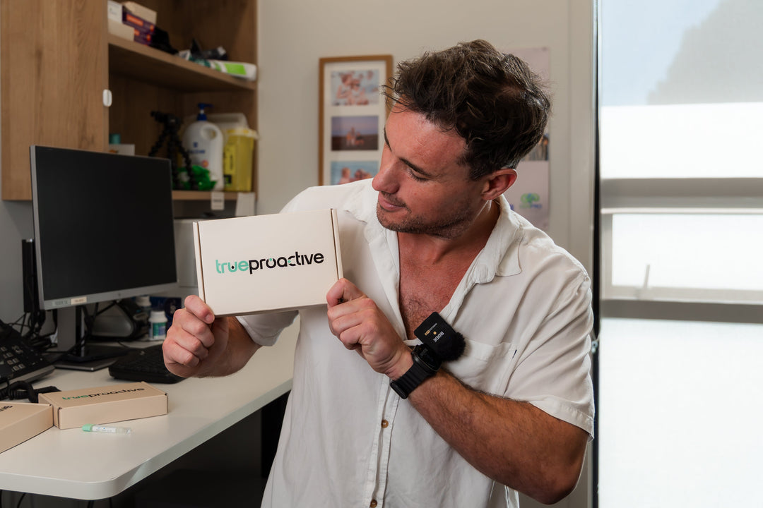 Dr Clive Price holding a True Proactive bowel cancer screening FIT test in his clinic
