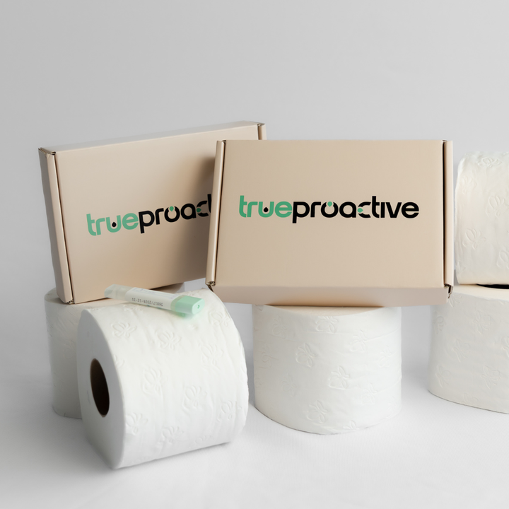 Two True Proactive bowel cancer screening FIT Test boxes with 'true proactive' branding and toilet paper rolls on a light gray background.